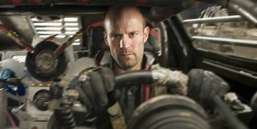 Jason Statham looks focused, sitting in a rugged vehicle in Death Race.