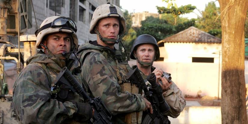 Two American soldiers and a journalist with a camera stand in a street in Baghdad in Generation Kill, 2008.