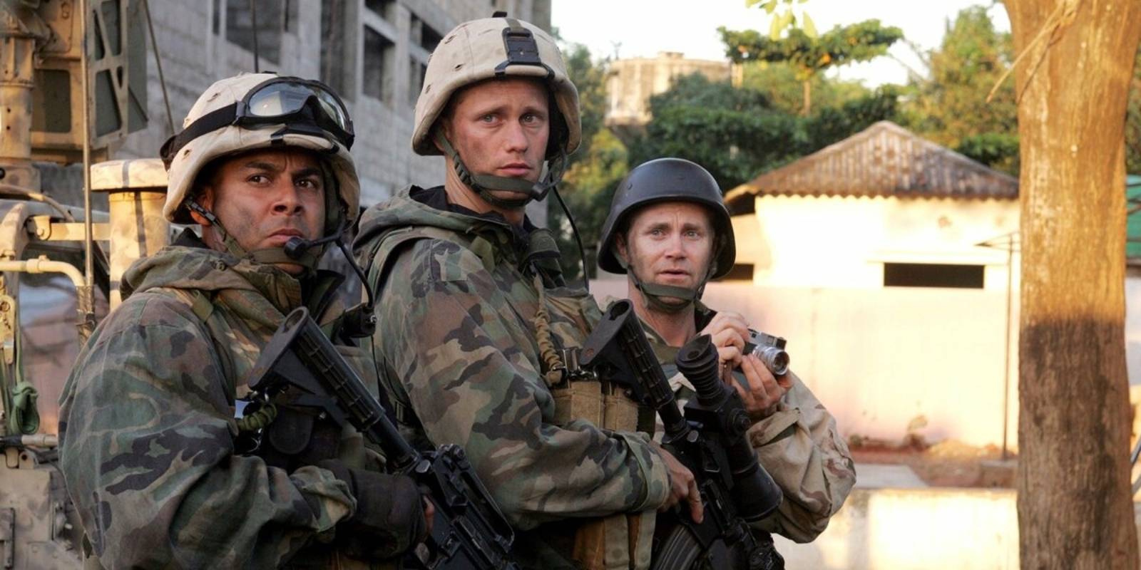 Two American soldiers and a journalist with a camera stand in a street in Baghdad in Generation Kill, 2008.