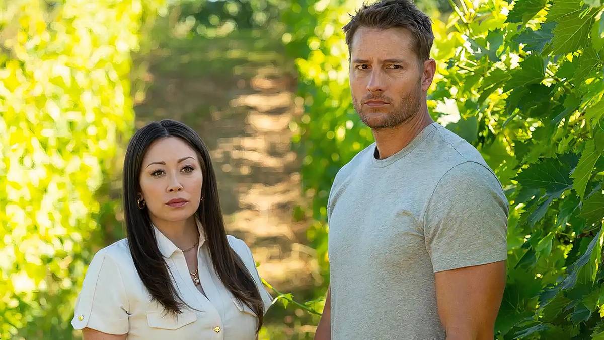 Fiona Rene as Reenie and Justin Hartley as Colter standing in a field on 'Tracker' .
