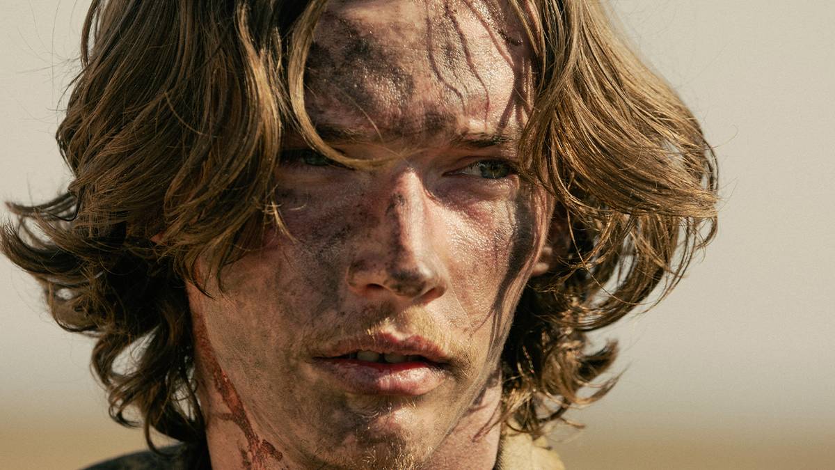 Close-up of Jacob Lofland in Landman covered in dirt and dried blood on his neck.