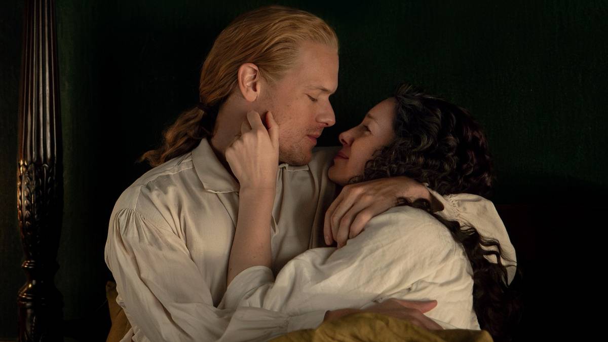 Sam Heughan and Caitriona Balfe cuddling in bed