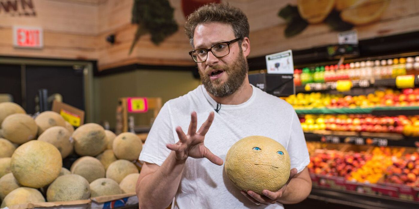 Seth Rogen holding a melon with a face on it for a Sausage Party prank