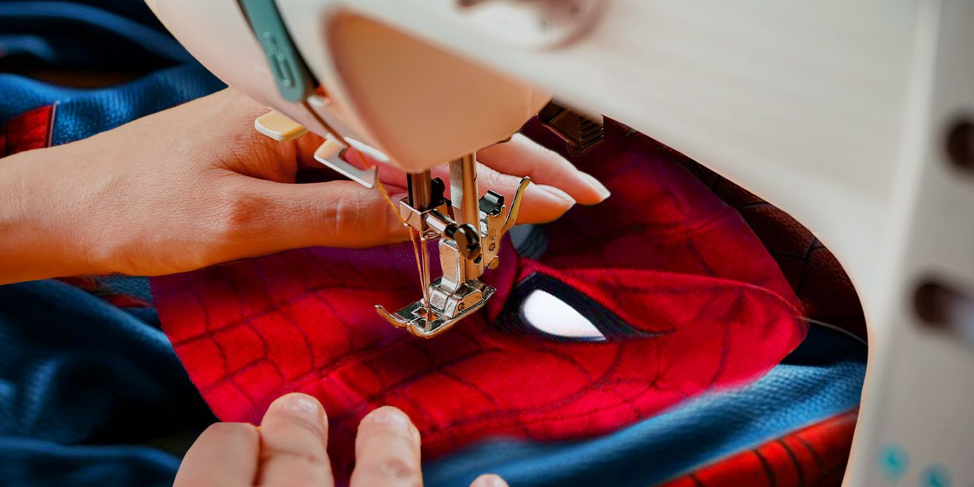A woman's hand sowing a Spider-Man suit.