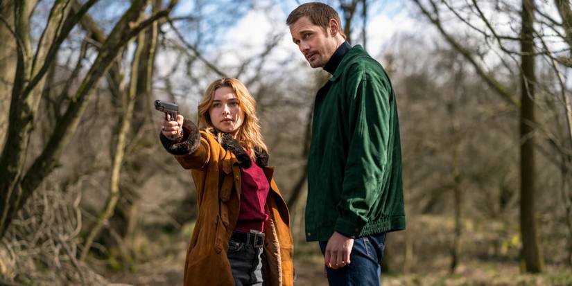 A man watches as a girl points a gun to the distance in The Little Drummer Girl
