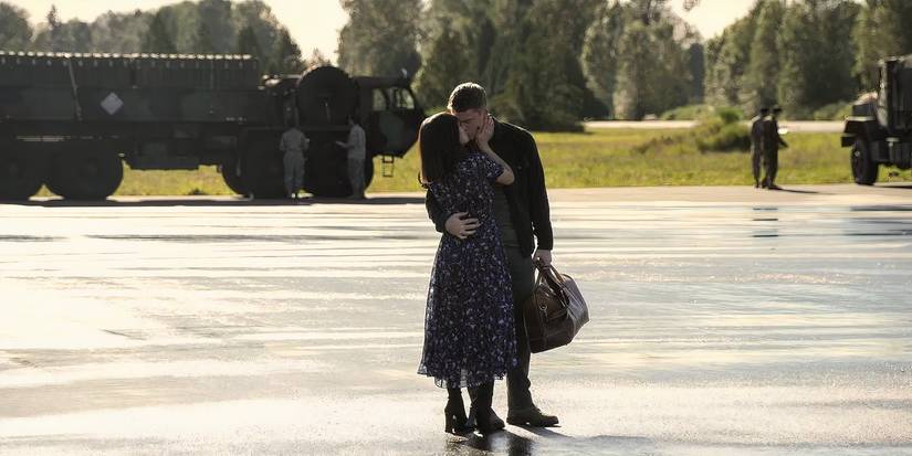 Luciane Buchanan as Rose and Gabriel Basso as Peter kissing on a tarmac on 'The Night Agent'