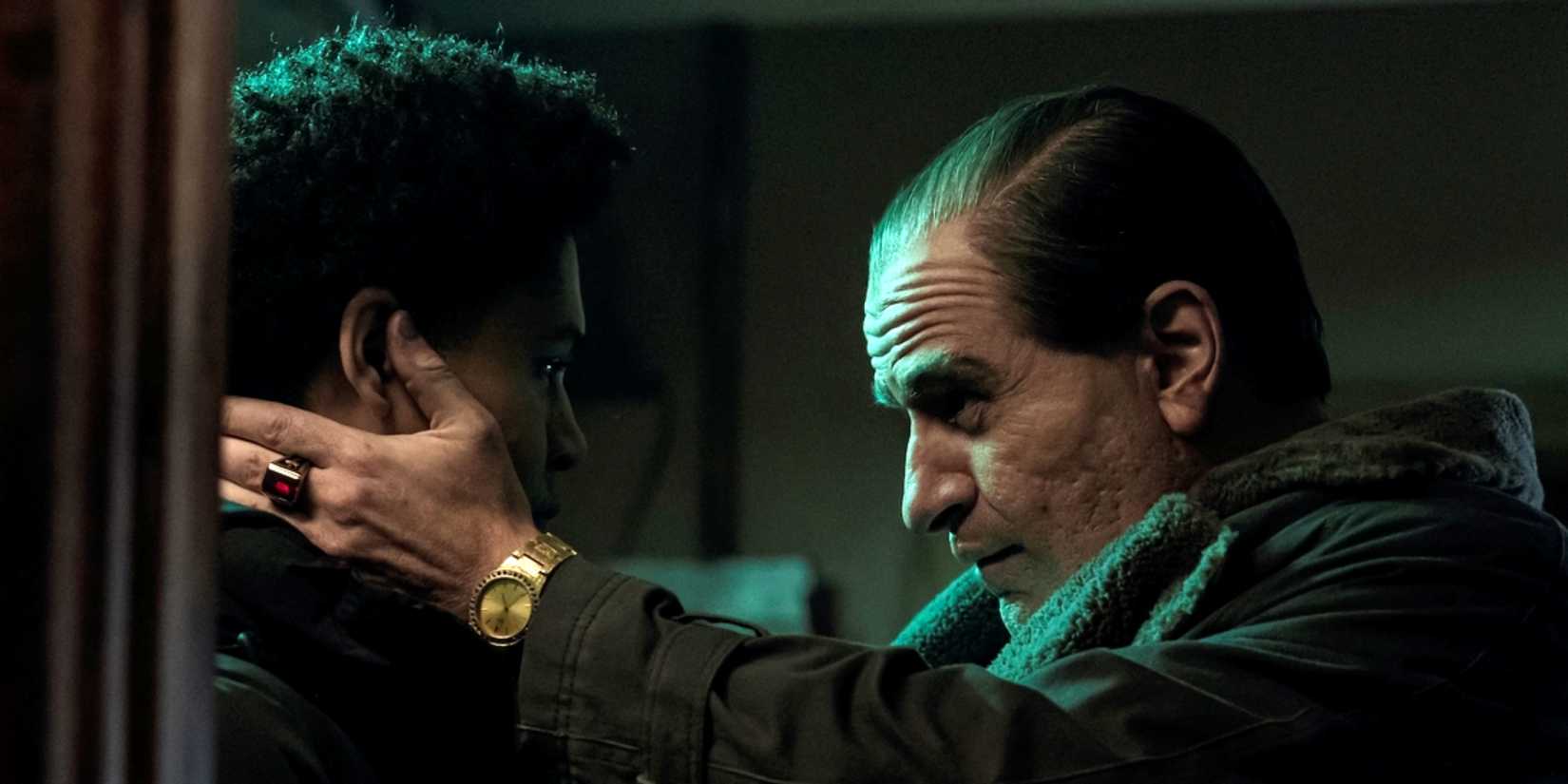 Colin Farrell as Oz Cobb putting his hands on either side of the face of Rhenzy Feliz as Victor in The Penguin