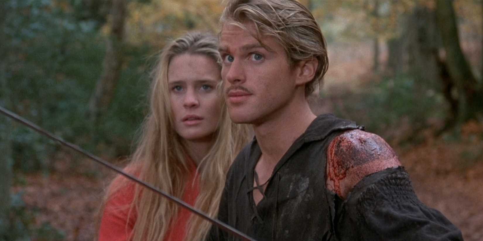 Westley stands on guard with his sword while Buttercup stands behind him in The Princess Bride.