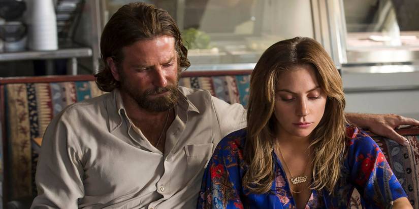 Bradley Cooper and Lady Gaga sitting down looking sad in 'A Star is Born'
