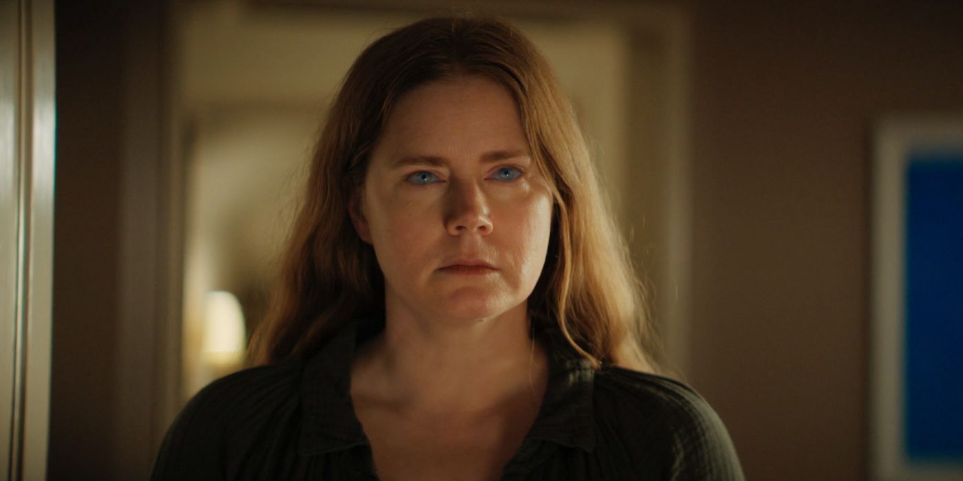 Amy Adams with glowing light blue eyes in Nightbitch.