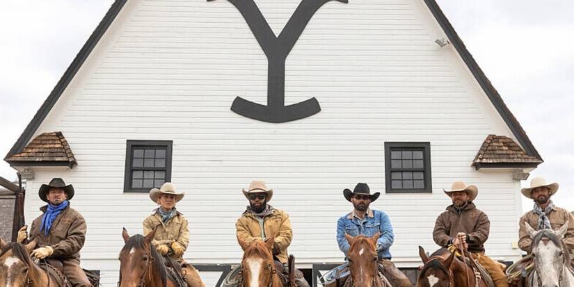 The cast of Yellowstone Season 5 on horses in front of a white building.
