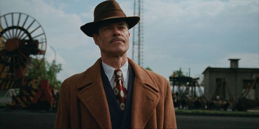 Guy Pearce as Harrison Lee Van Buren looking to the distance in The Brutalist.