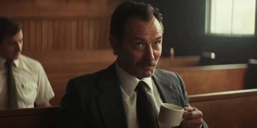 Jude Law, sitting on a church pew, as Terry Husk in The Order