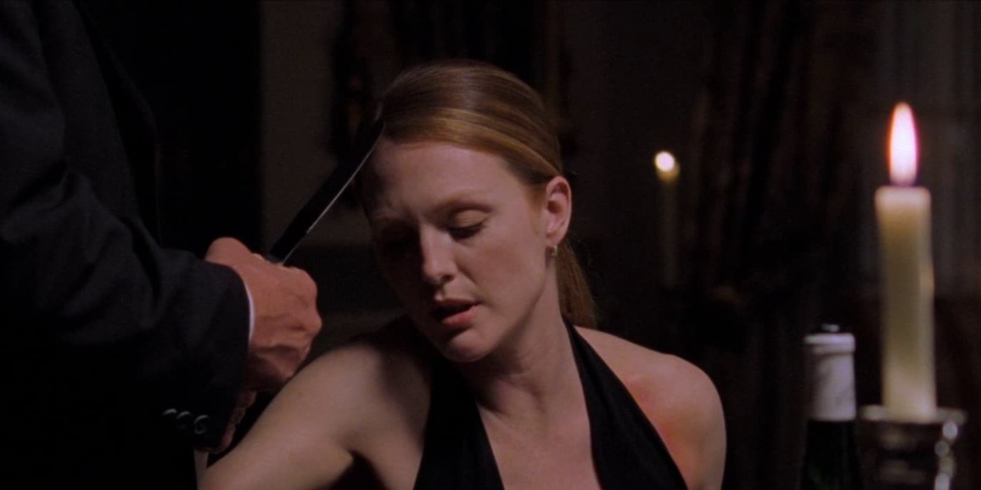 Julianne Moore as Starling sits at a fancy dinner table in Hannibal (2001)