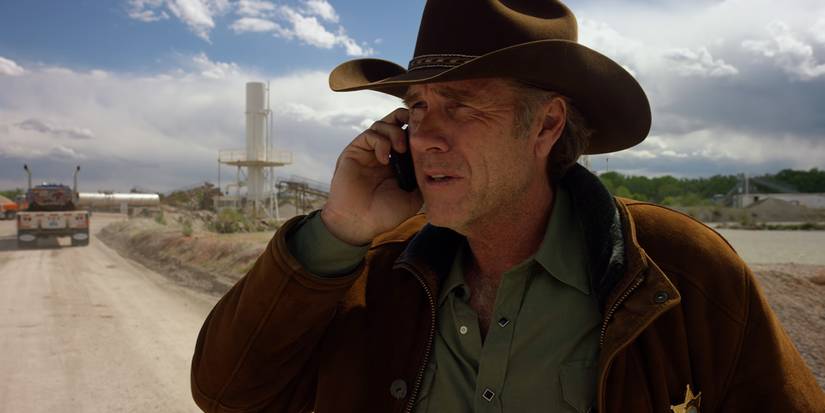 Sheriff Walt Longmire (Robert Taylor) on the phone at oil fields in the Longmire episode The Calling Back.