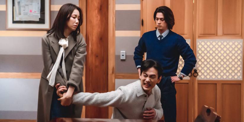 A woman twists a man's arm while another person watches in Love to Hate You.