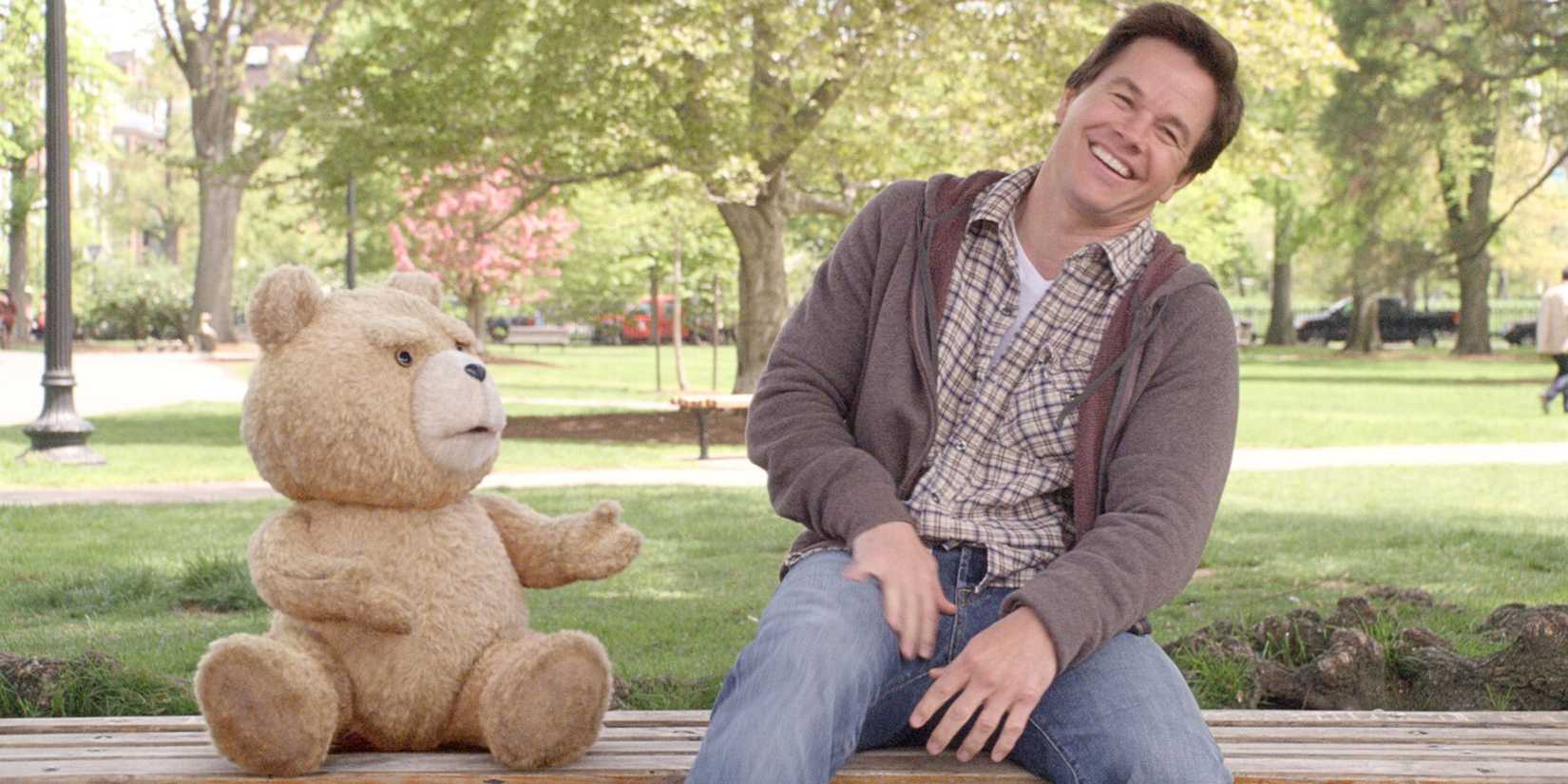 Mark Wahlberg sitting on a bench in a park with Ted voiced by Seth MacFarlane in Ted (2012)