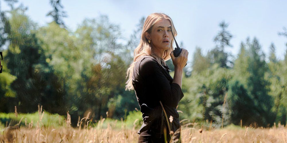 melissa roxburgh in the hunting as rebecca henderson standing on an open field with a radio