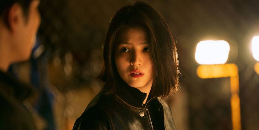Ji-woo (Han So-hee) in a black leather jacket looks left at a man who's mostly off-screen in My Name.