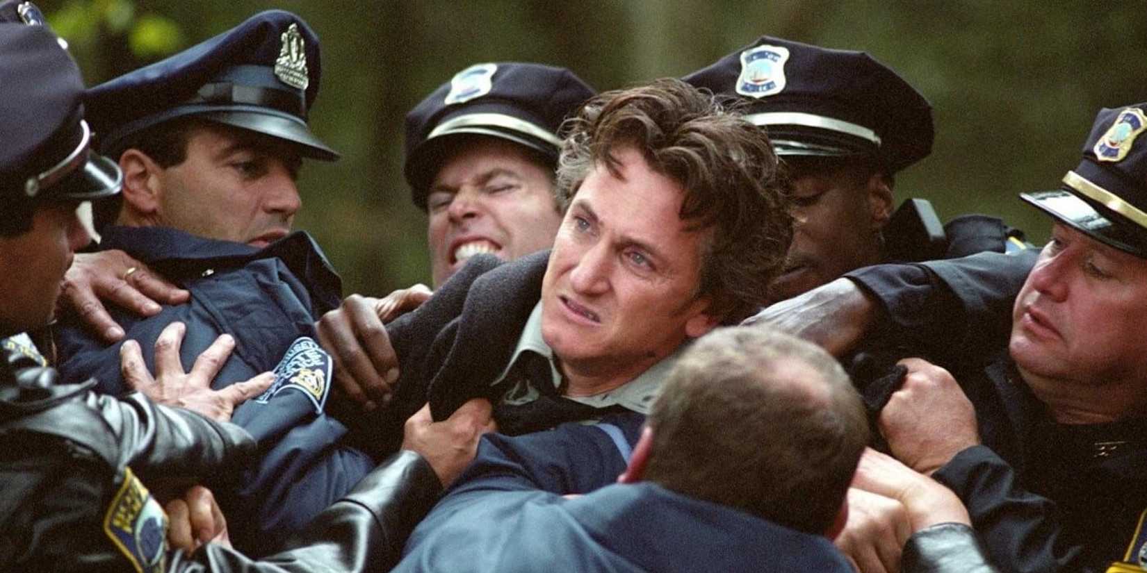 Jimmy being restrained by several policemen in Mystic River 