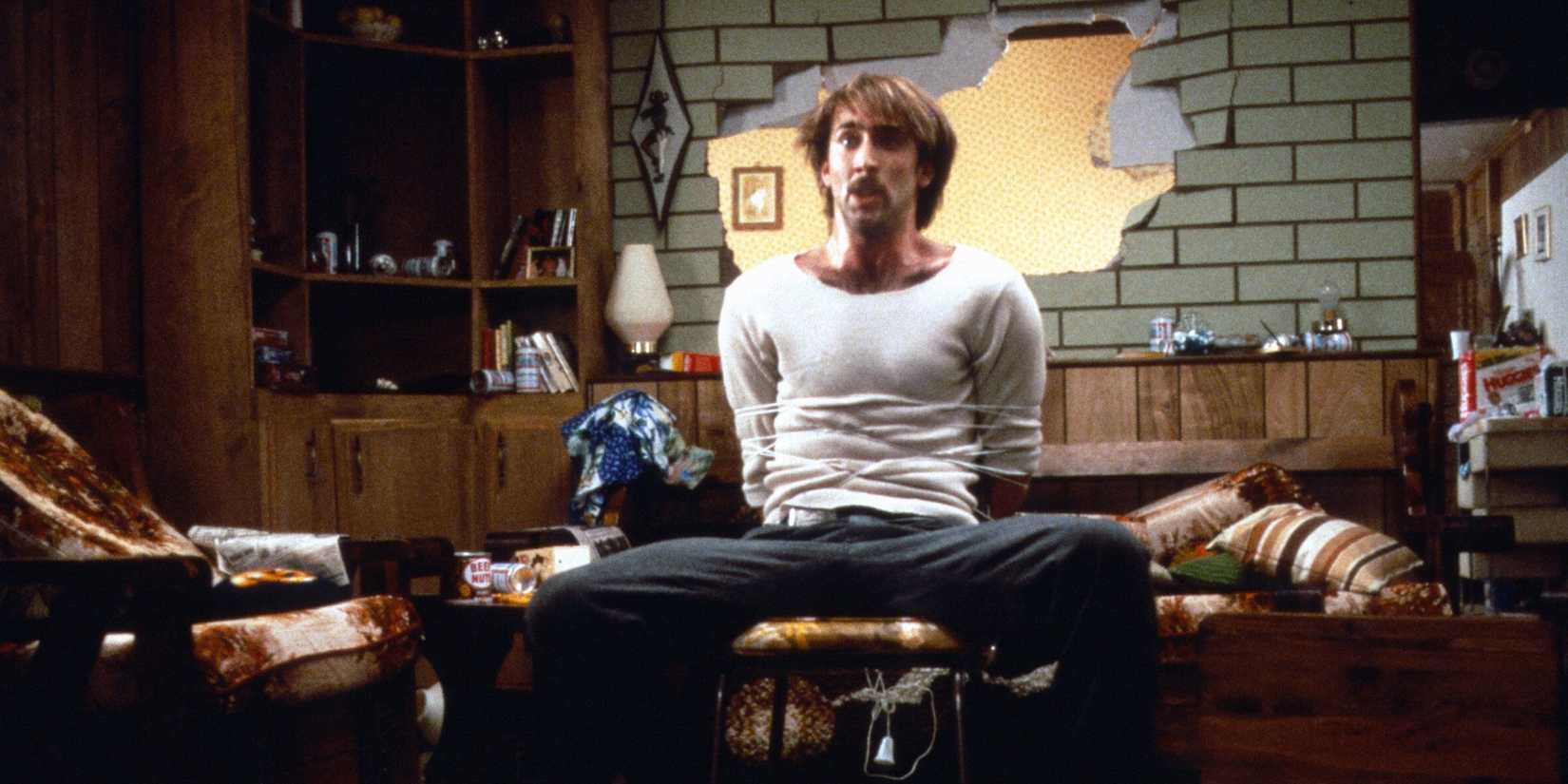 Nicolas Cage tied to a chair in Raising Arizona