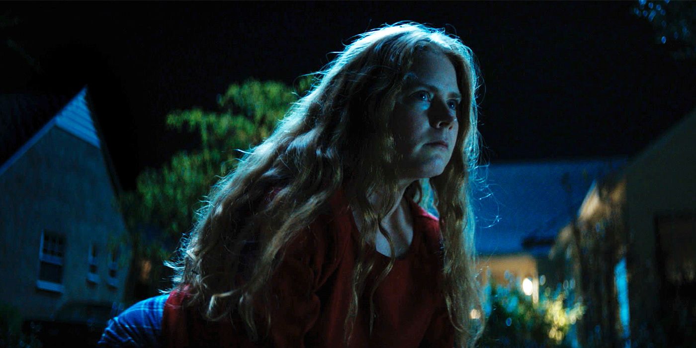Mother (Amy Adams) crawling on the ground outside at night in Nightbitch
