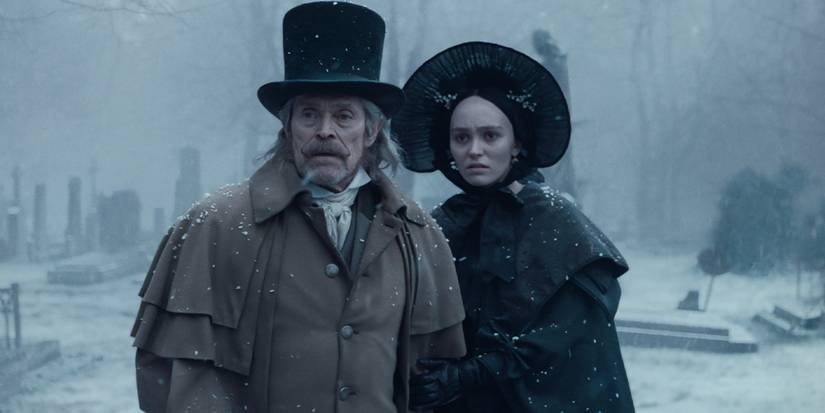 Professor Albin (Willem Dafoe) and Ellen (Lily-Rose Depp) in a cemetery in the snow in Nosferatu