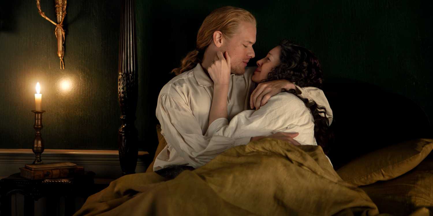 Caitriona Balfe as Claire with Sam Heughan as Jamie holding each other in bed in Season 7 Pt 2 of Outlander