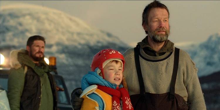 Rauno (Jorma Tommila) with an arm around the shoulders of his son Pietari (Onni Tommila) in the sunrise with Aimo (Tommi Korpela) standing behind them in "Rare Exports"