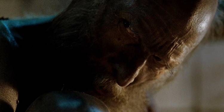 An old, naked man sitting with his knees pulled up to his chest and looking evilly over his shoulder in "Rare Exports"