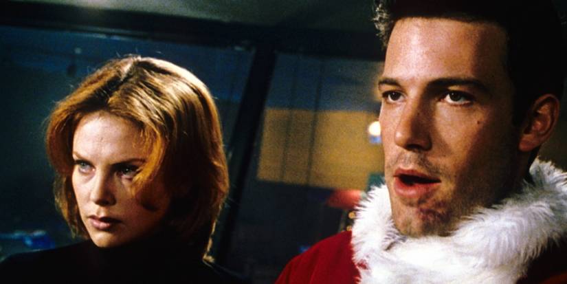 Ben Affleck in a Santa suit and Charlize Theron looking in the same direction in Reindeer Games.