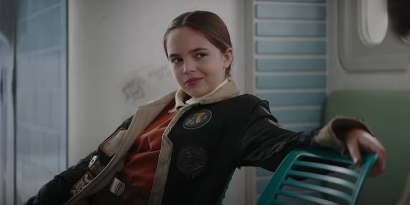 Ryan Kiera Armstrong as Fern sitting down with her arm leaning across a chair in Star Wars: Skeleton Crew