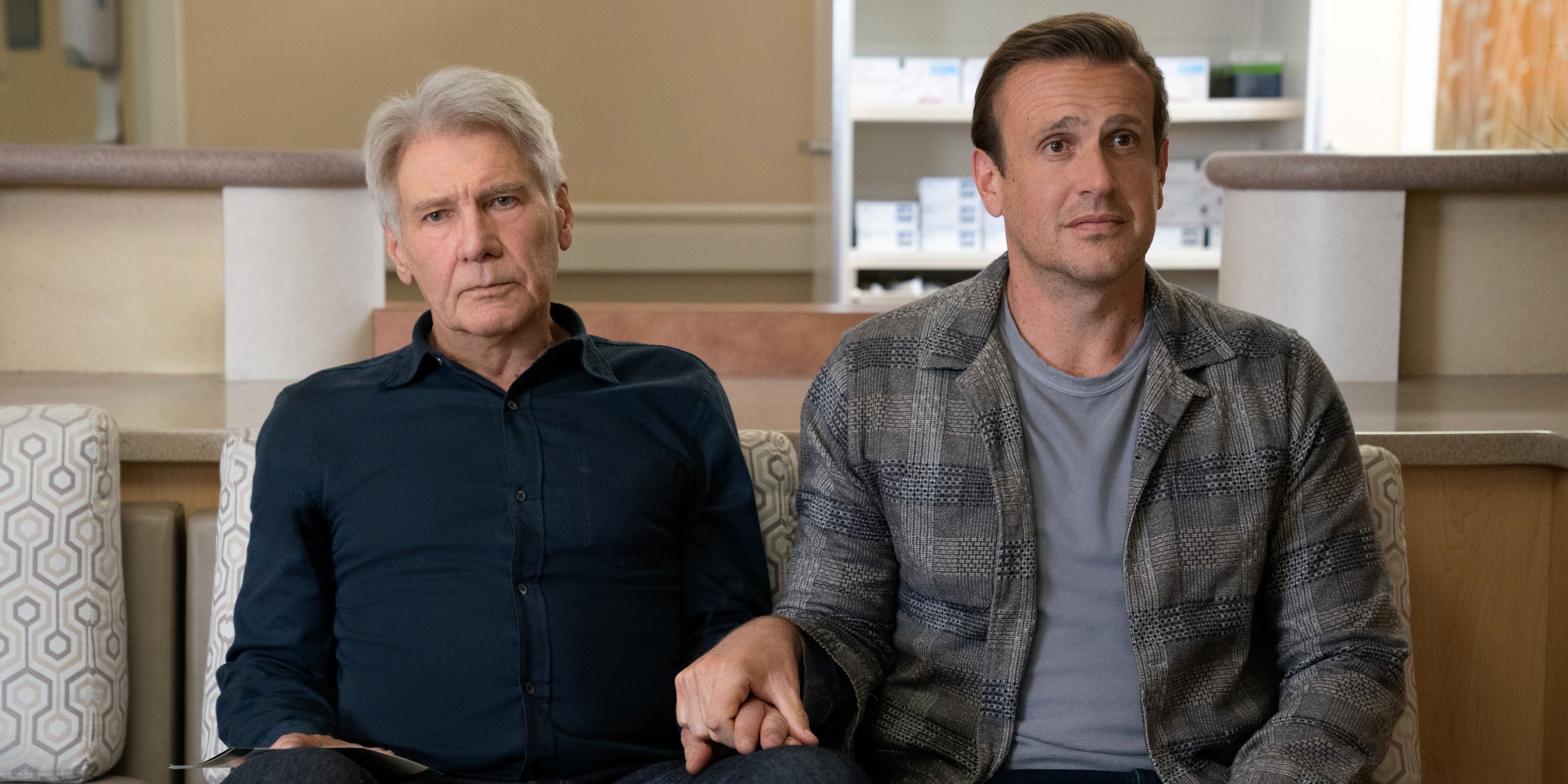 Jason Segel as Jimmy and Harrison Ford as Paul sitting together and holding hands in Season 2 of Shrinking