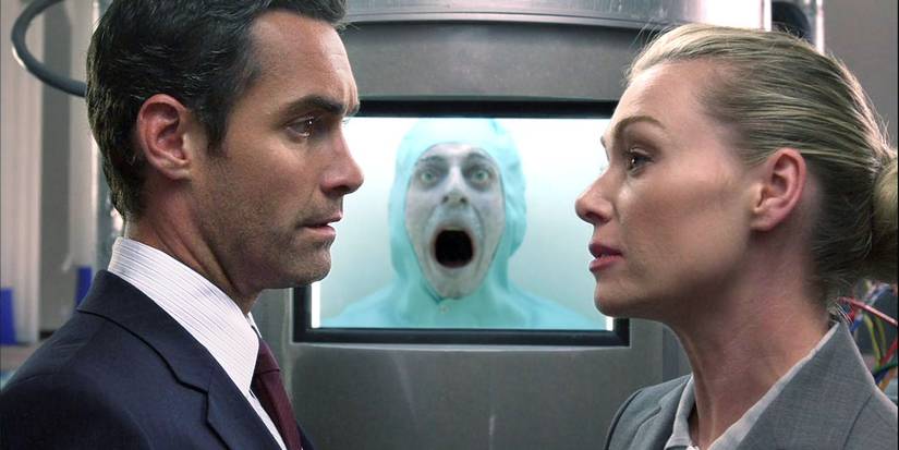 Ted (Jay Harrington) and Veronica (Portia de Rossi) talking in front of a frozen Phil (Jonathan Slavin) in 'Better Off Ted'