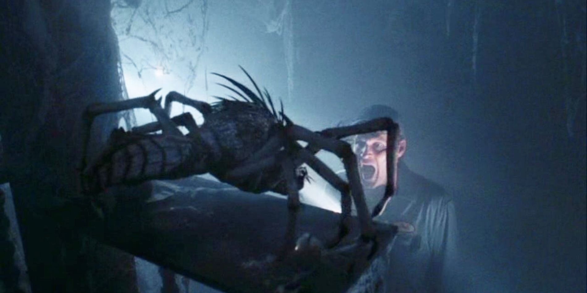 A man screaming at a small, spider-like monster in The Mist