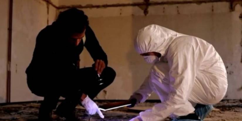 Two people gather evidence from a crime scene, one is wearing a biohazard suit in The Real CSI: Miami.
