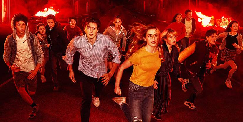 The cast of The Society running with a reddish background with small fires behind. 