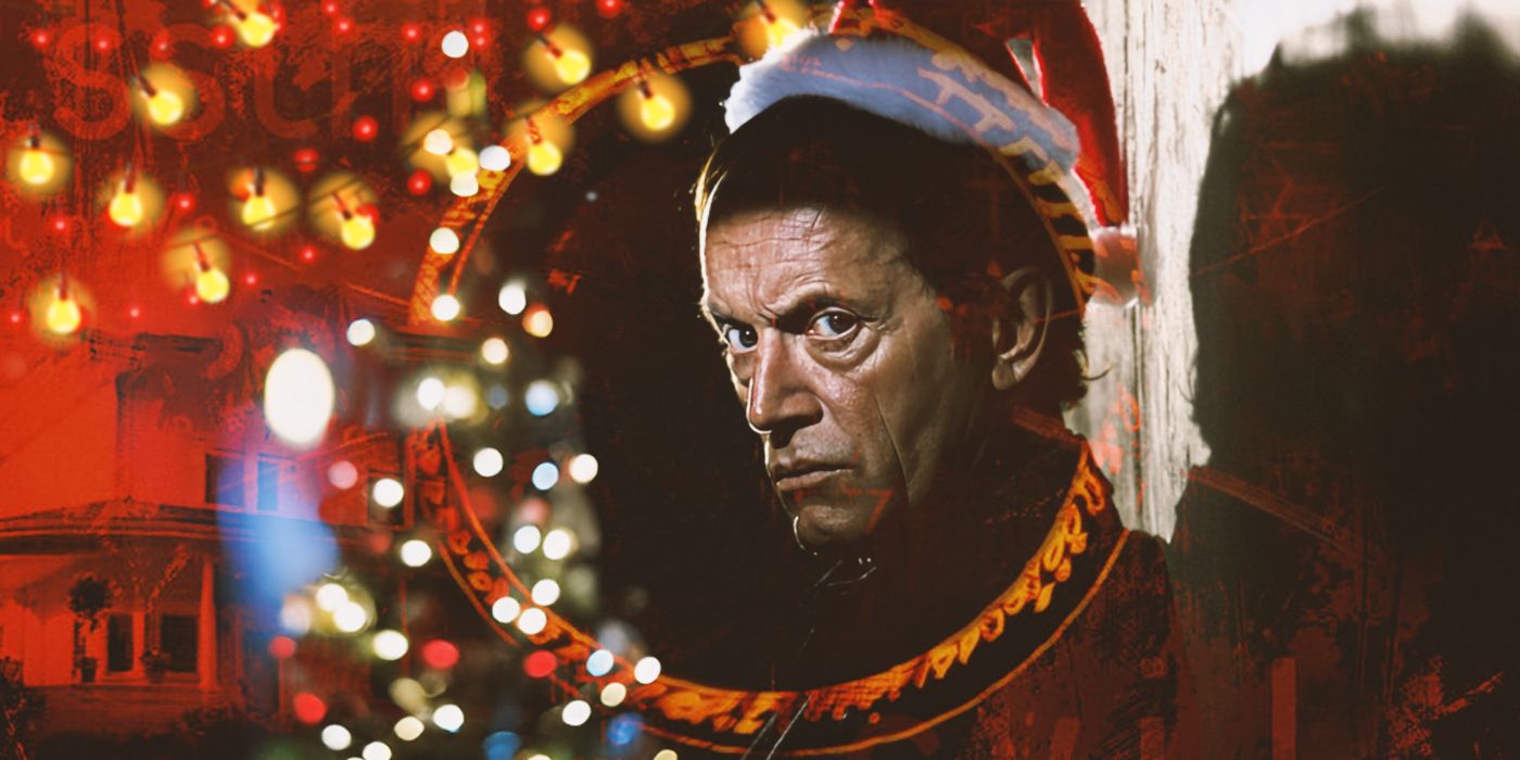 A man wearing a santa hat and looking dubiously at the camera with christmas decorations behind him.