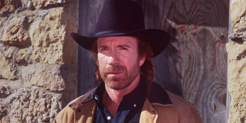 Chuck Norris as Cordell Walker stands beside a building on 'Walker, Texas Ranger'