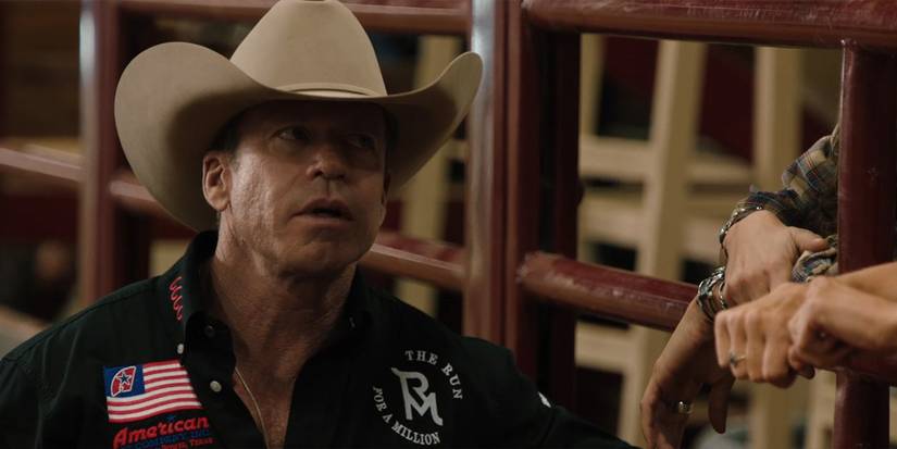 Taylor Sheridan as Travis Wheatley talks to someone by a gate in Yellowstone Season 5, Episode 13.
