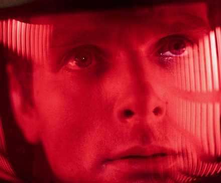 An astronaut under a red light looking ahead in 2001- A Space Odyssey.