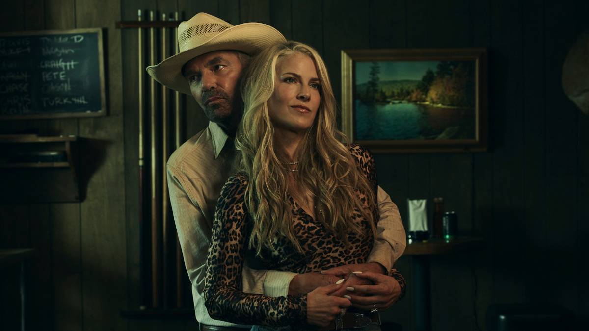 Billy Bob Thornton as Tommy stands behind and embraces Ali Larter as Angela in Landman.