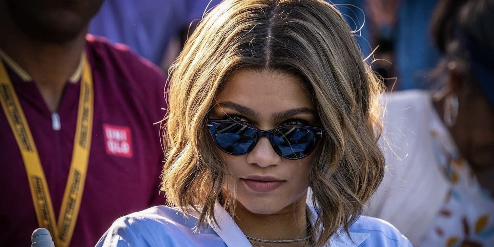 Zendaya wearing sunglasses and looking towards the camera in the film Challengers.