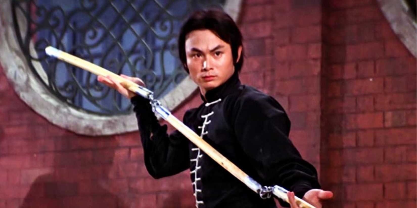 Gordon Liu holding a set of nunchucks with a furrowed brow in Heroes of the East, 1978.