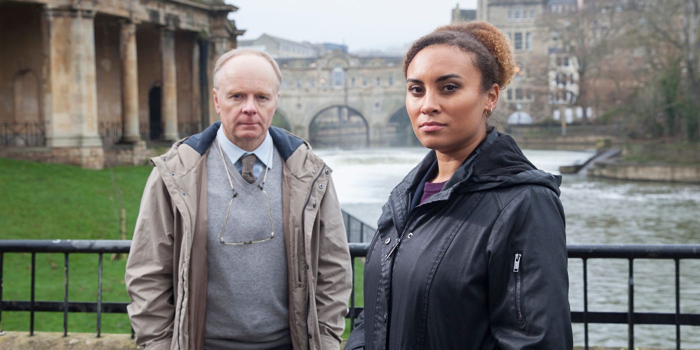 Jason Watkins and Tala Gouveia standing together in front of a river in McDonald &amp; Dodds