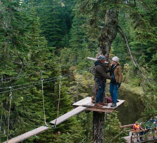 Mel and Jack at the Lumberjack Games, standing on a platform attached to a tree in season 3 of Virgin River.