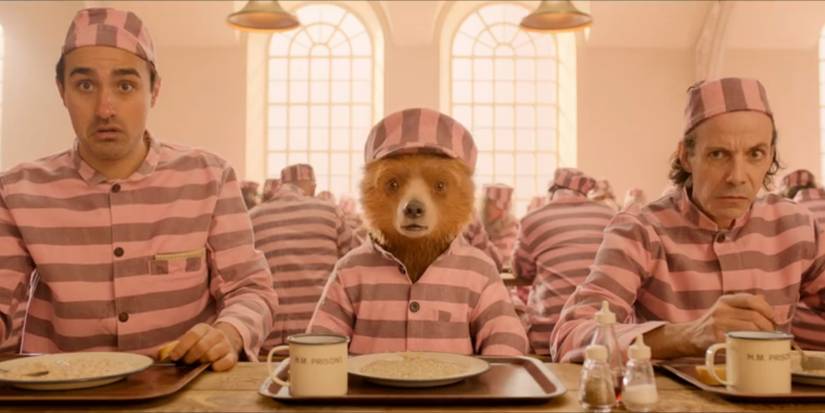 The Professor, Paddington and Phibs all sit at the lunch table while looking alarmed in 'Paddington 2'.