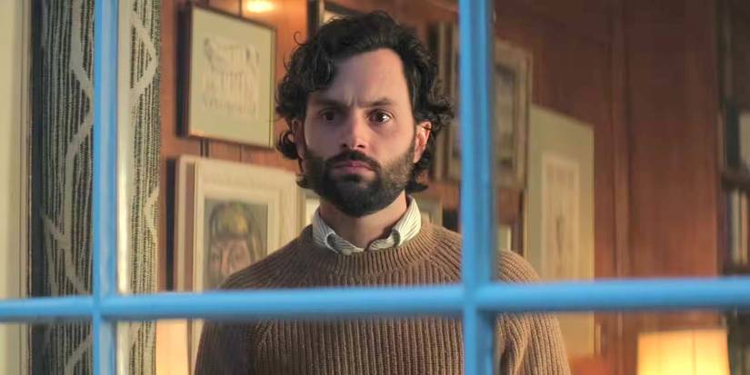 Penn Badgley as Joe Goldberg looking out his apartment window in 'You' Season 4.