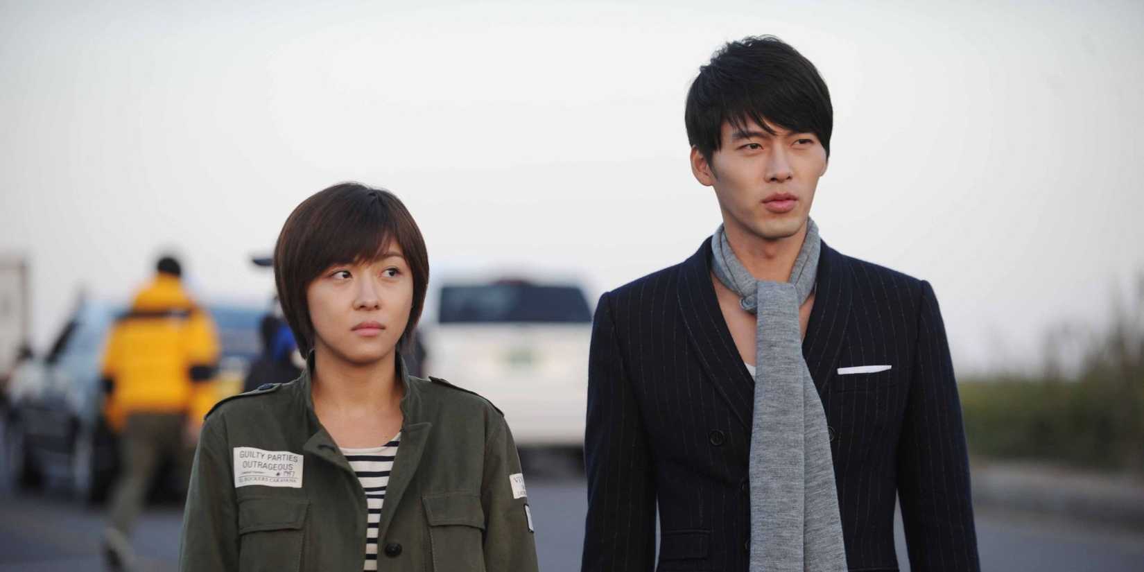 The two main characters walk side by side down a street in Secret Garden.