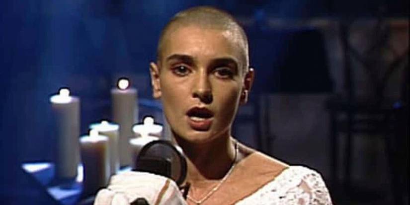 Sinead O'Conner staring into the camera while singing into a mic on SNL.